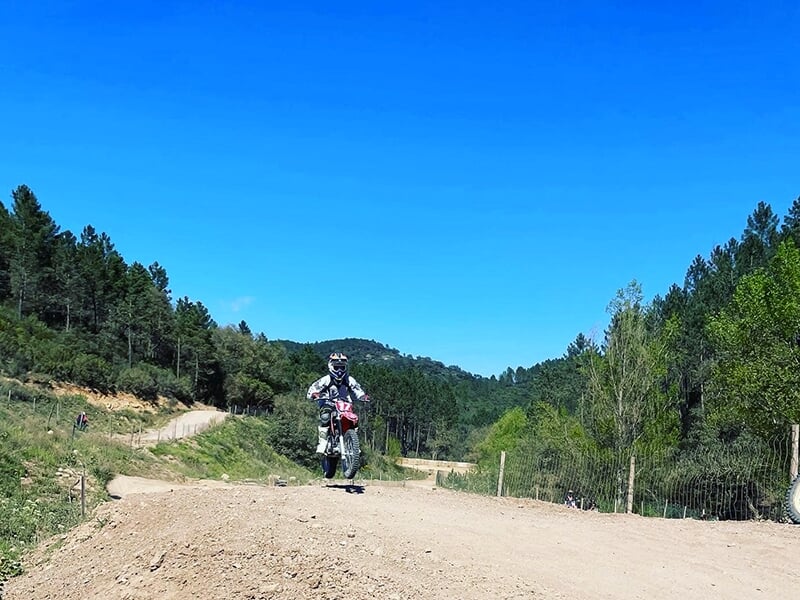 Un jeune motard sur une piste s'entraîne en ligne droite en pleine nature