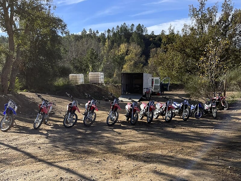 Des motos de cross garées sur un terrain de motocross situé en pleine nature