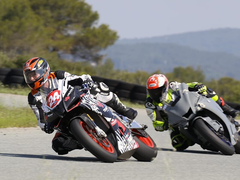 Deux pilotes de moto enchaînent les tours de piste sur un circuit de vitesse pendant un stage de perfectionnement