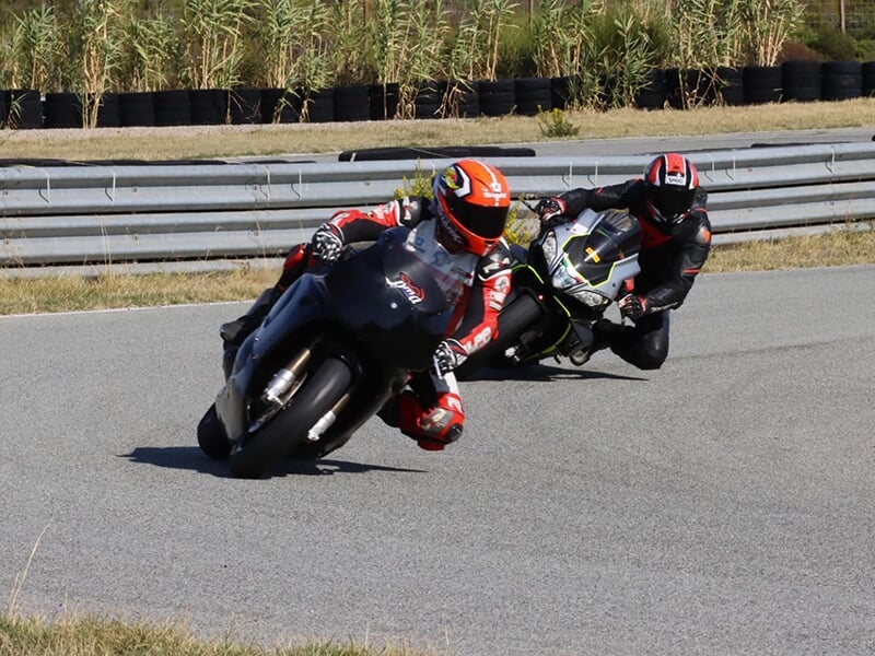 Deux motards roulent sur un circuit de vitesse pendant une session de roulage libre.