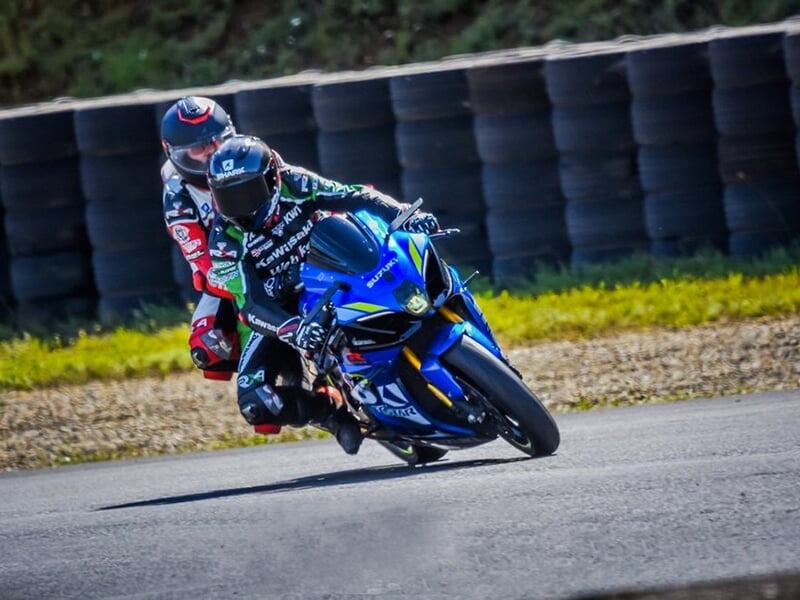 Un pilote et son passager sur l'asphalte d'un circuit de vitesse.