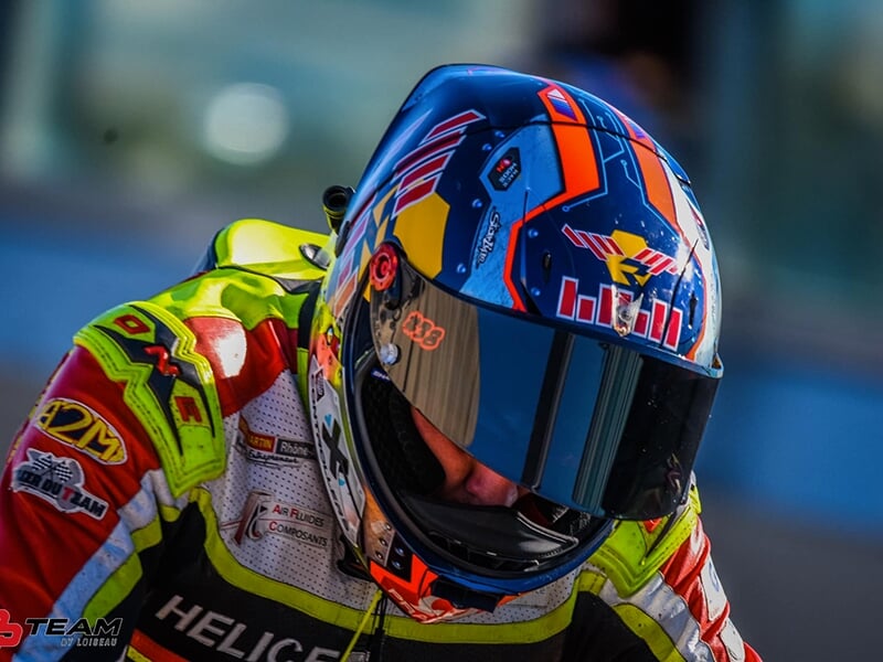Un pilote de moto de vitesse avec un casque intégral et unecombinaison en cuir
