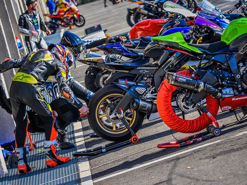Changement de pneumatiques dans les stands pendant une journée de roulage libre à moto