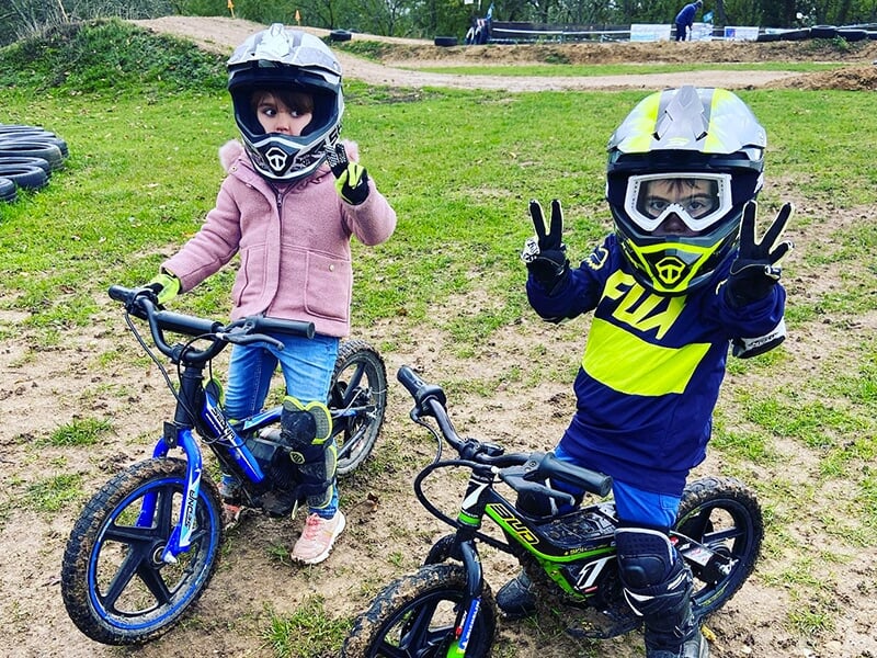 Deux enfants sur des draisiennes électriques lors d'un stage de pilotage motocross