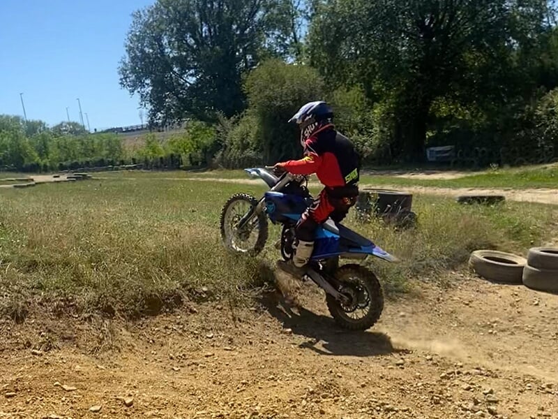 Un jeune pilote prend une petite bosse à moto lors d'un stage d'initiation au motocross dans le département de Saône-et-Loire