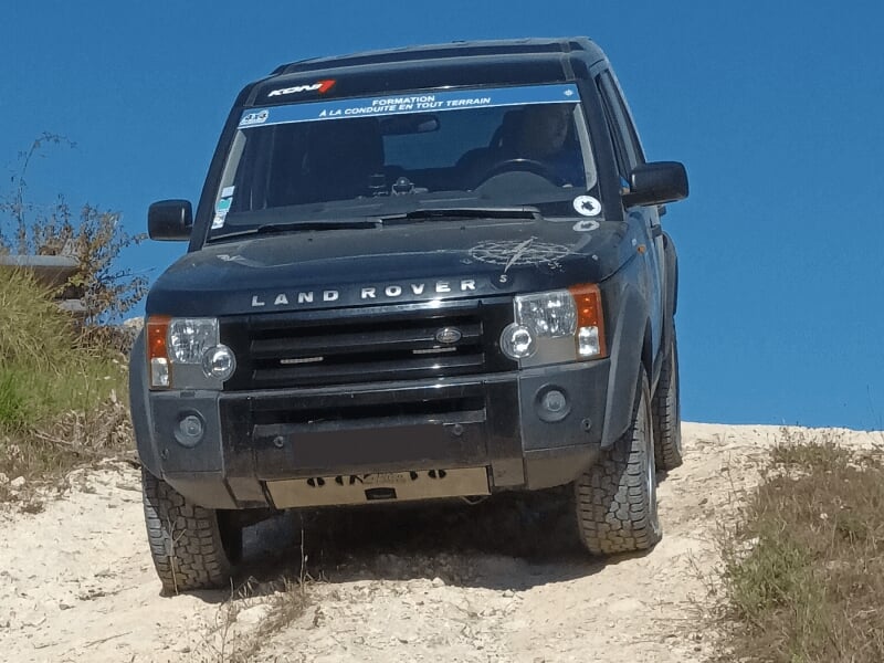 Un puissant 4x4 s'engage sur un terrain accidenté dans la région Nouvelle-Aquitaine lors d'un stage de pilotage