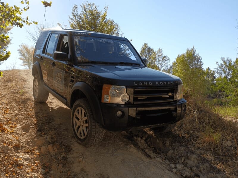 Un 4x4 Land Rover Discovery descend une portion d'une piste sablonneuse dans les Landes