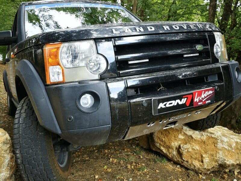 Gros plan sur le pare-chocs avant d'un Land Rover noir avec des pneus tout-terrain lors d'un stage 4x4.
