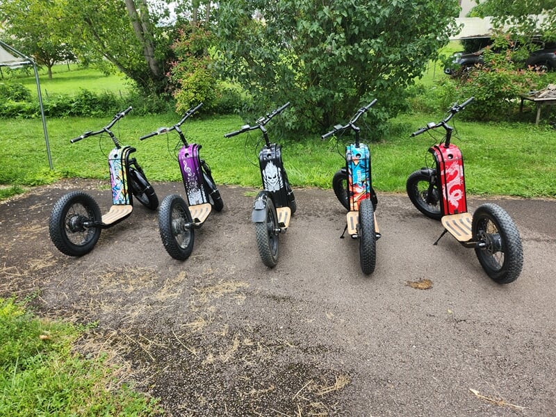 5 trotinettes électriques sur un chemin