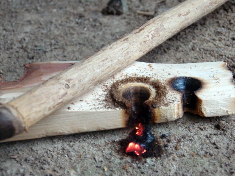 Une planche et un morceau de bois pour allumer un feu sans briquet