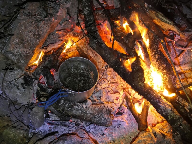 Un feu de camp sur le bivouac d'un stage de survie