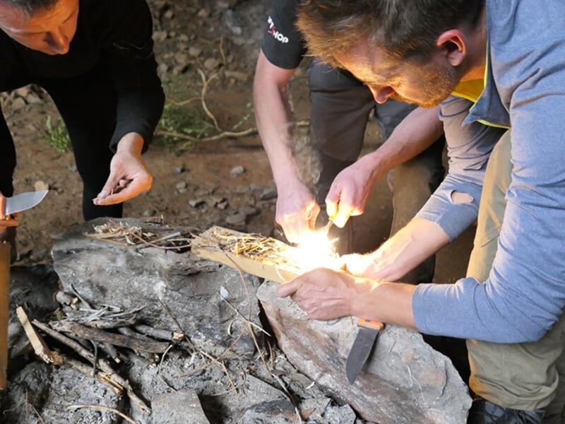 Un groupe d'aventuriers apprend à allumer un feu sans briquet lors d'un stage de survie
