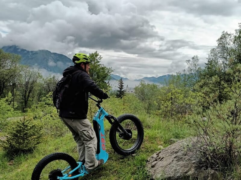 Homme en trottinette électrique admirant la vue sur la montagne