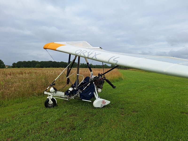 ulm pendulaire posé dans un champs