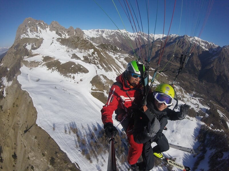 Deux personnes faisant du parapente à ski