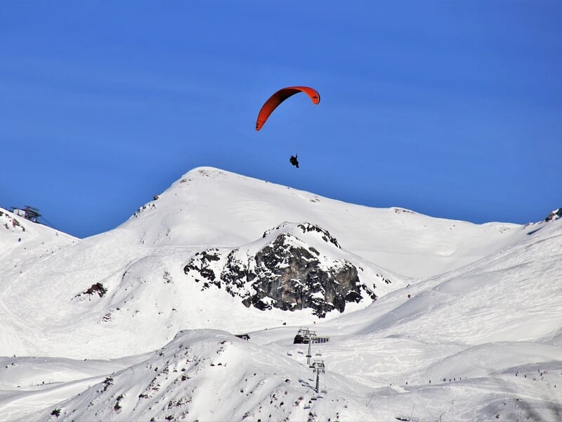 Parapente au dessus de la montagne enneigée