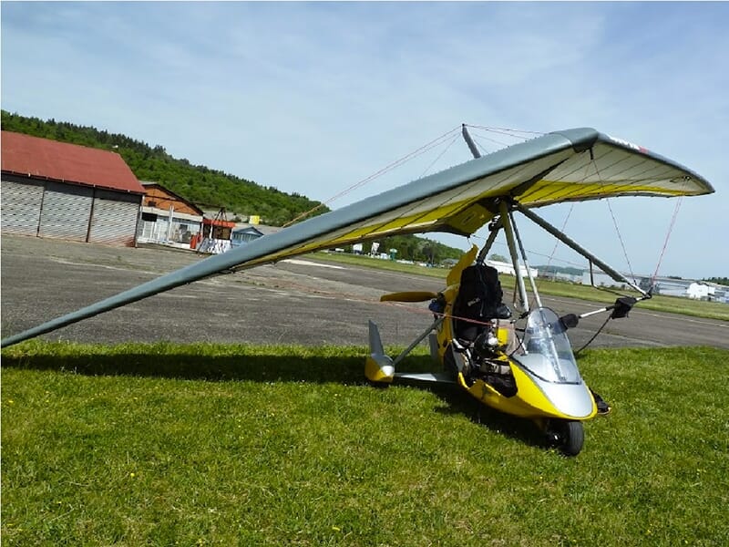 Le chariot motorisé d'un ULM pendulaire posée sur la pelouse d'un aérodrome dans les Vosges