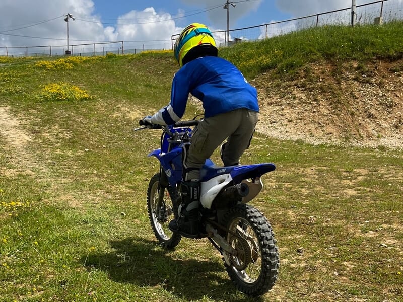 enfant montant une butte en moto-cross