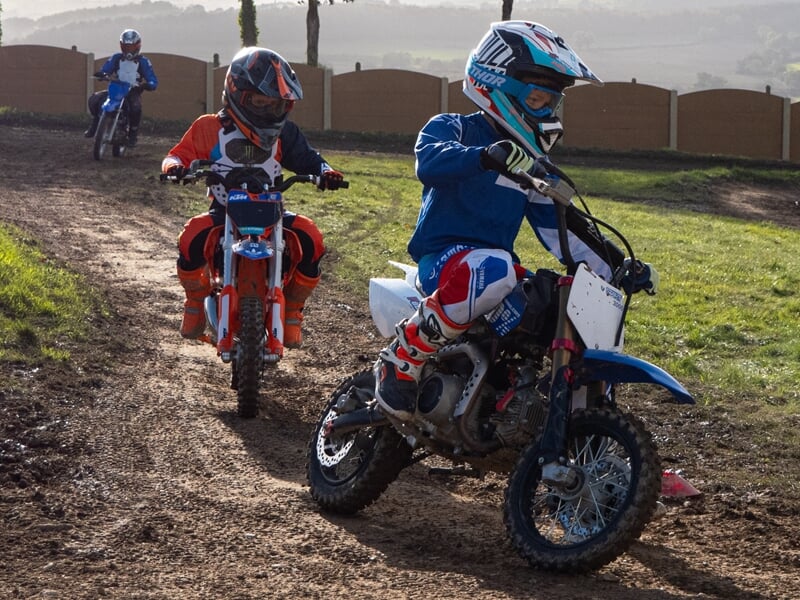 Groupe d'enfant pratiquant la moto-cross sur terrain privé