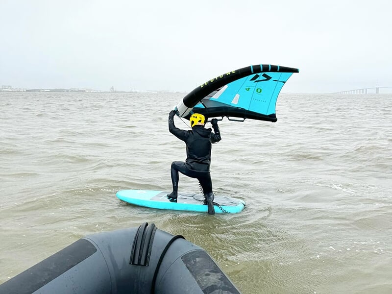 Un homme commence à pratiquer le wingsurf à genoux