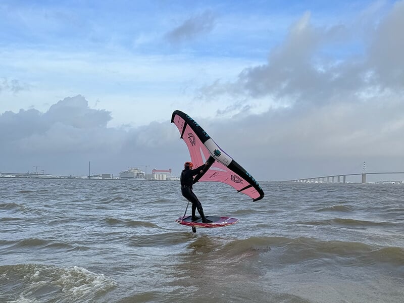 Un homme pratique le wingsurf, un mélange de kitesurf et de planche à voile