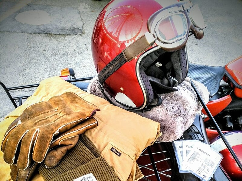 Casque de moto rouge vintage avec gants et veste en cuir.