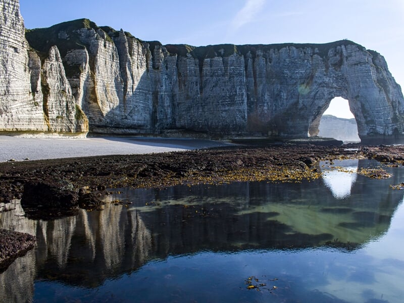 Photo d'une arche de pierre creusée dans les falaises d'Étretat