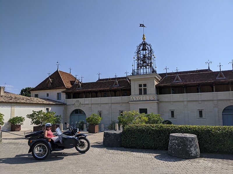 Une moto avec side-car stationnée devant le domaine Angélus sous un ciel dégagé