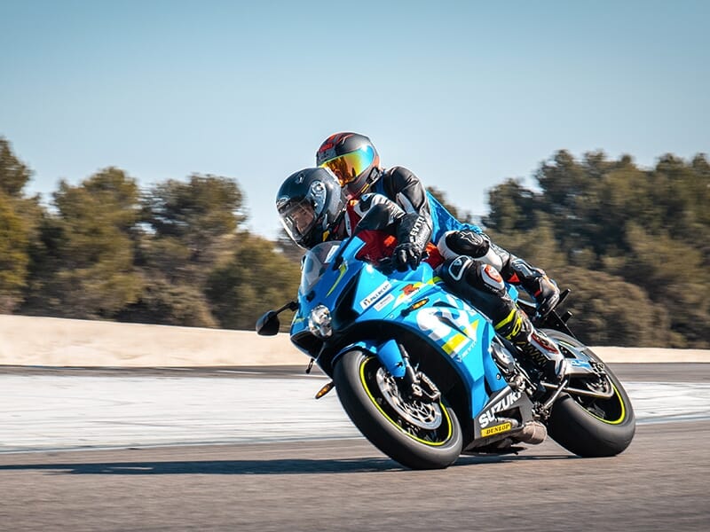 Duo de motards en combinaison sur une moto bleue 