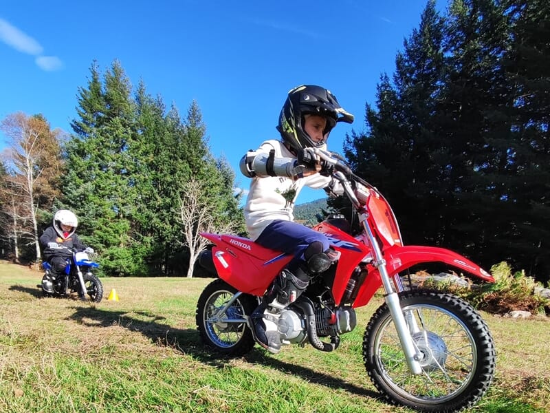 Deux enfants pratiquant la moto dans un pré