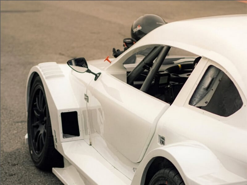 Détail de l'aile avant d'une voiture de course blanche avec une prise d'air.
