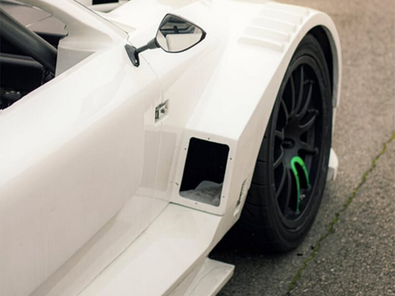 Détail de l'aile avant d'une voiture de course blanche avec une prise d'air.