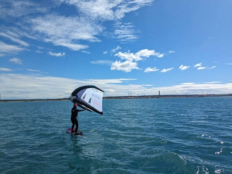 Personne pratiquant le wingfoil sur la mer