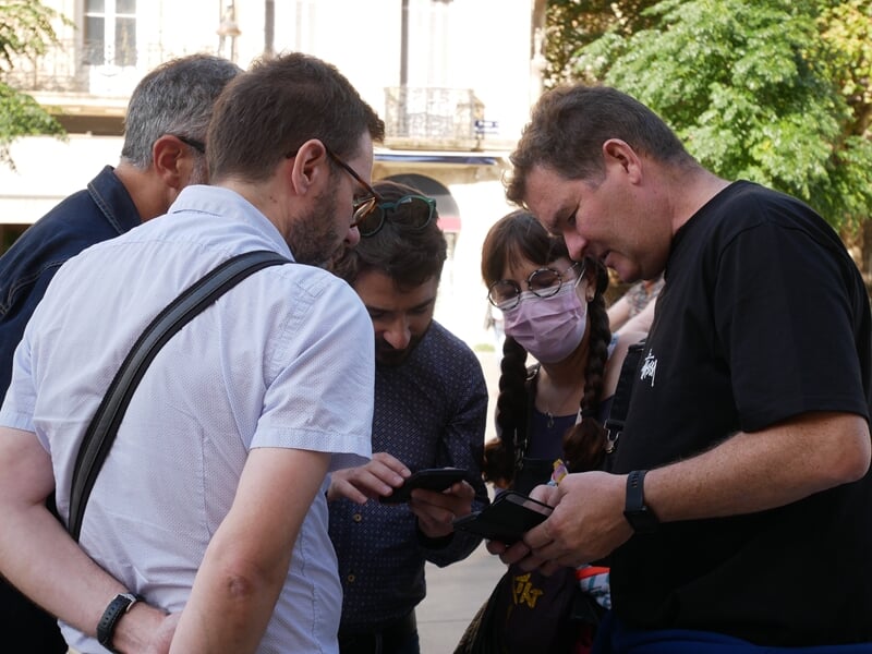 Groupe de personnes sur smartphone faisant un escape game outdoor
