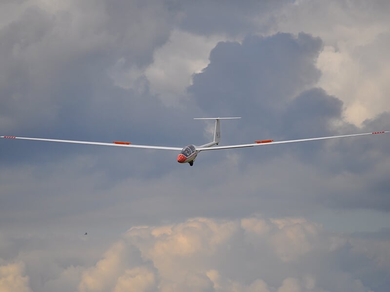 Planeur en vol d'initiation au stage baptême à la base ULM de Bailleul sous un ciel nuageux