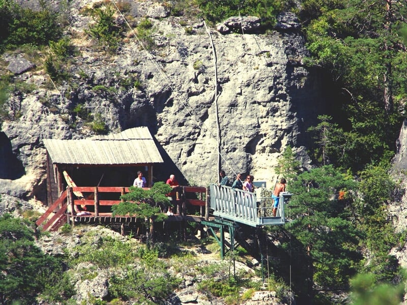 Une passerelle à flanc de falaise avec de la verdure autour
