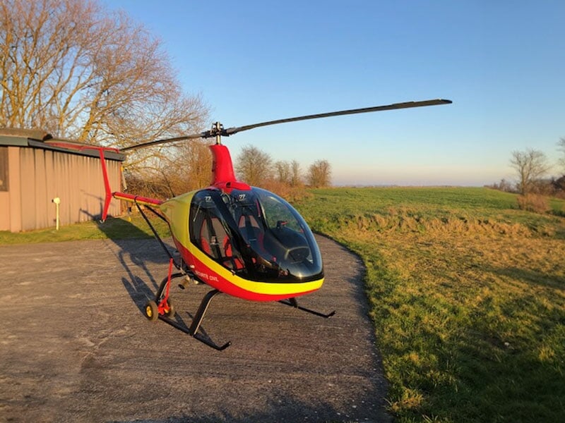 Hélicoptère ULM posé au sol au milieu d'un champ
