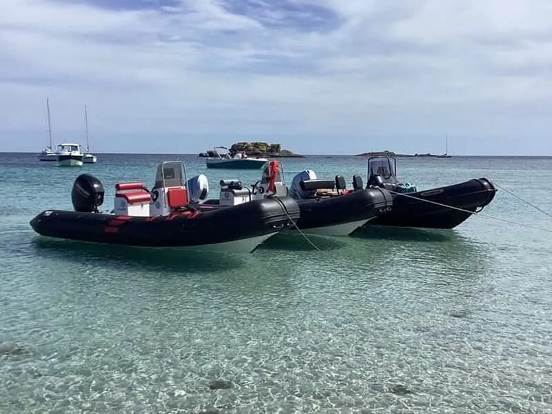 Deux bateaux pneumatiques noirs amarrés, prêts pour une balade en bateau