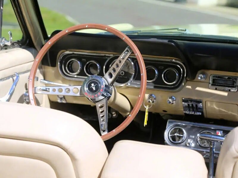 Intérieur d'une Ford Mustang avec volant en bois et tableau de bord rétro.