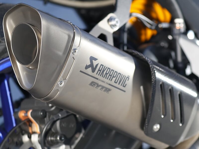 Gros plan sur un échappement Akrapovic installé sur une moto Yamaha, mettant en valeur sa finition métallique.