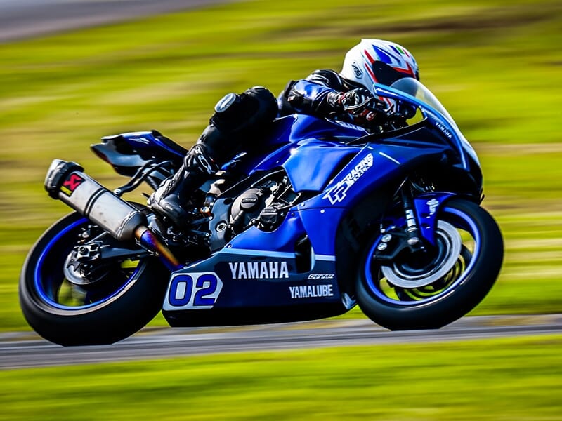 Motard en position aérodynamique sur une Yamaha n°02 en pleine accélération sur la piste.