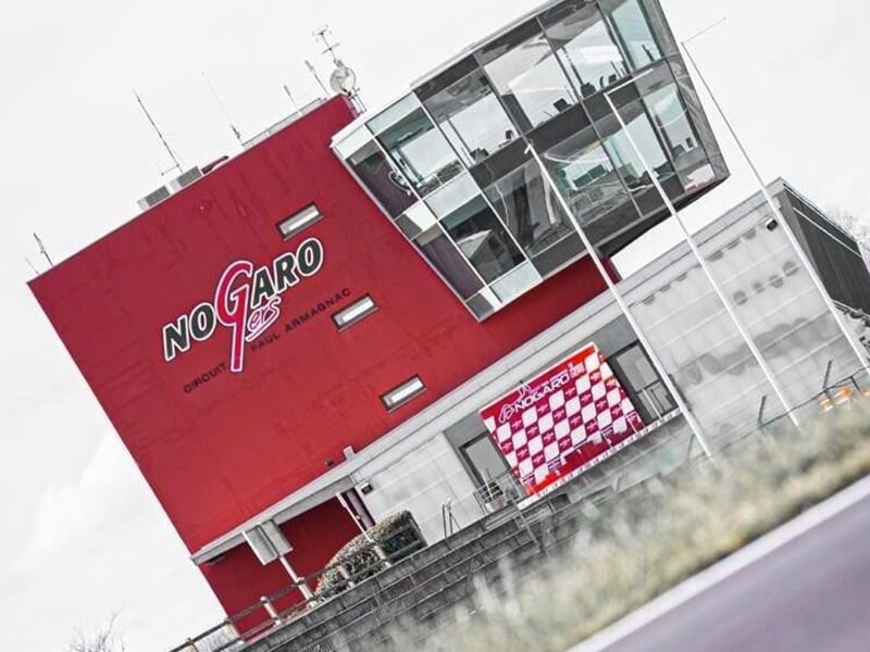 Vue du bâtiment principal rouge du circuit de Nogaro, avec le logo 