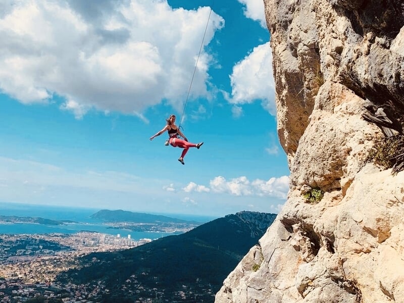 Femme faisant de la descente en rappel avec vue sur le Var