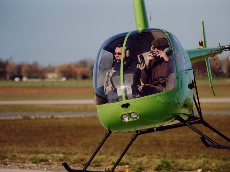 un robinson r22 en plein décollage sur une piste d'hélico