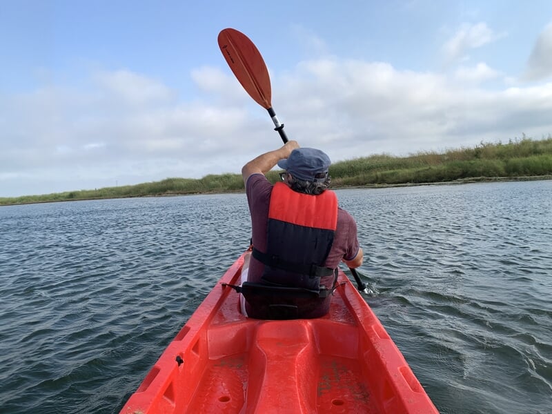 Personne vue de dos pratiquant le kayak