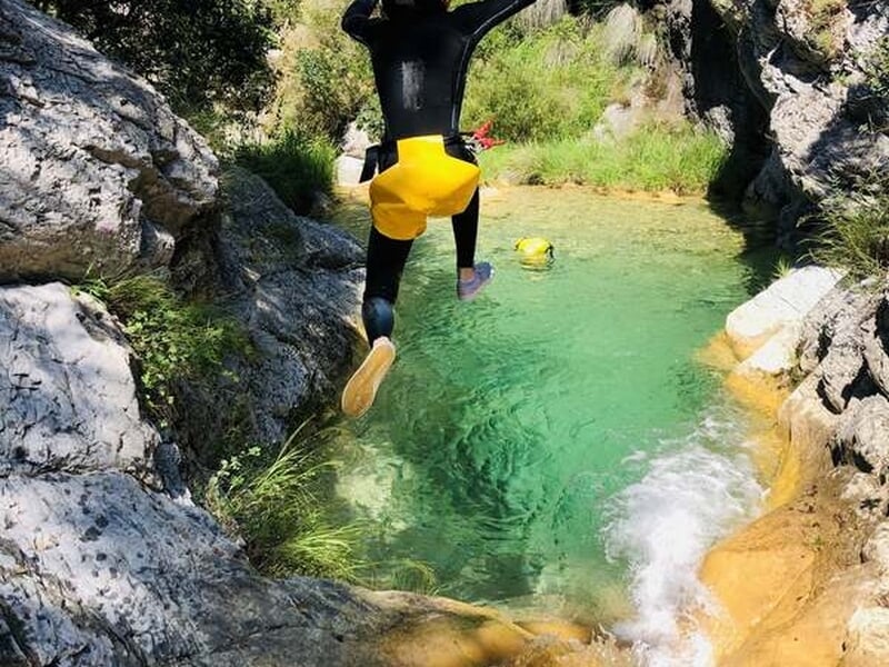 Personne sautant dans une vasque de canyon