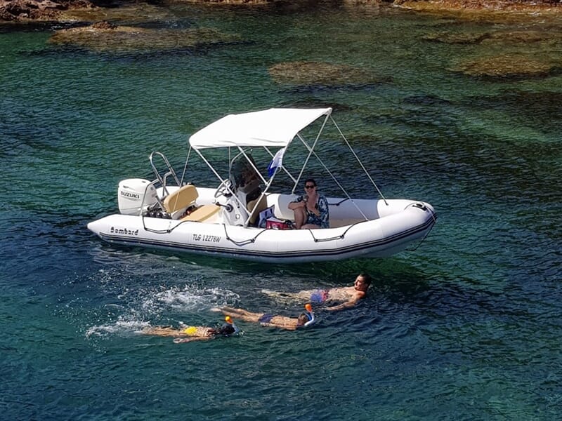 Groupe de touristes à bord d'un bateau à moteur dans une calanque isolée de la Côte d'Azur