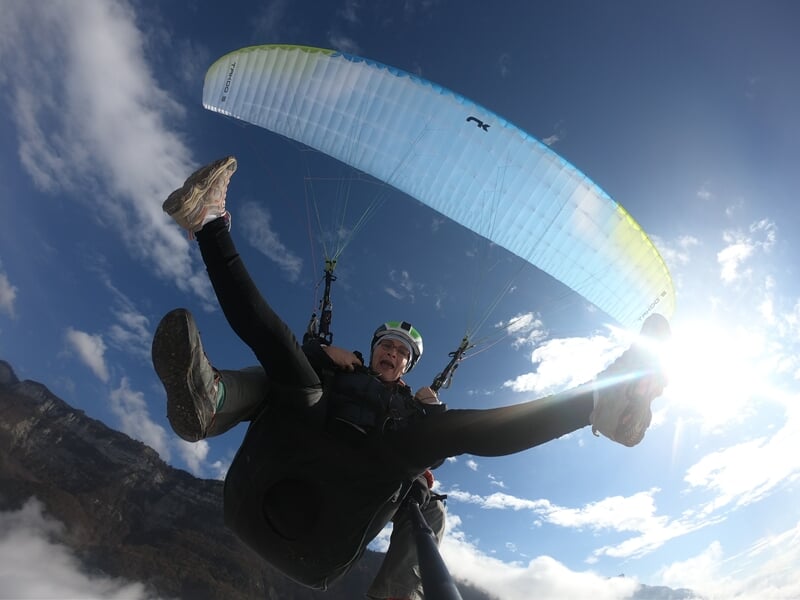 Deux personnes faisant du parapente vues de dessous