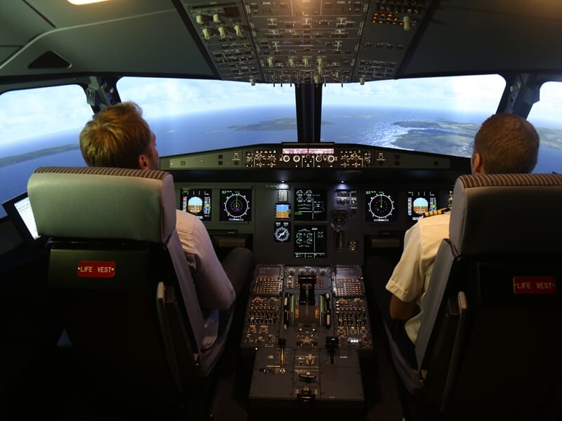 Deux hommes installés dans un simulateur de vol Airbus A320