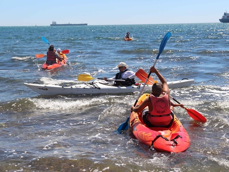 Un groupe de personnes pratiquant le kayak sur l'eau